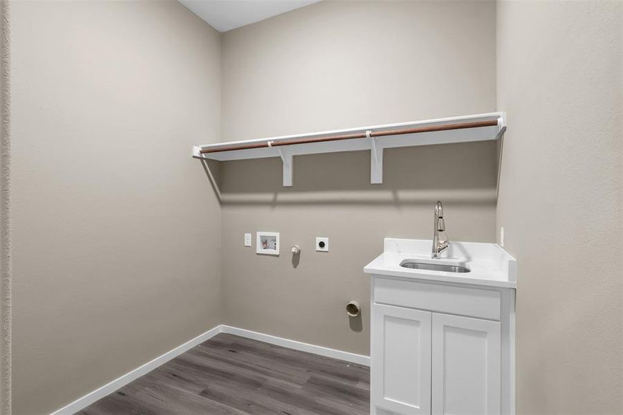 Laundry room featuring sink, hookup for a washing machine, cabinets, dark hardwood / wood-style flooring, and hookup for an electric dryer