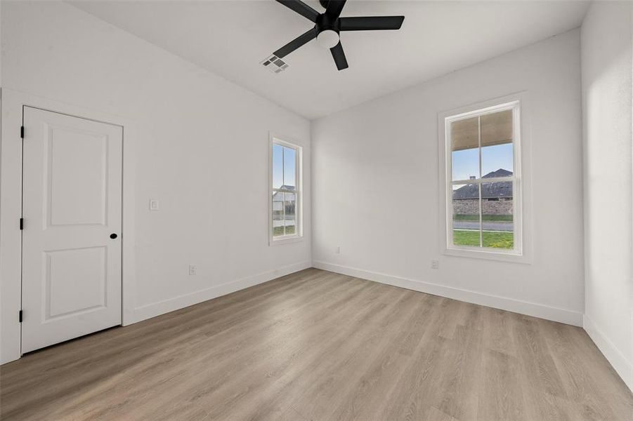 Spare room with light wood-style flooring and a ceiling fan Spare room with light wood-style flooring and a ceiling fan