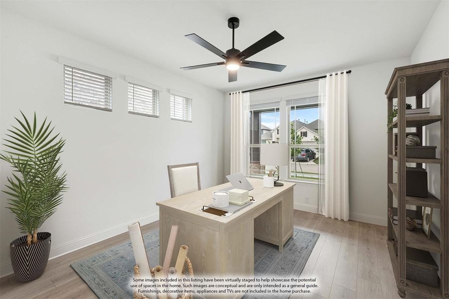 Home office with light wood desk, ceiling fan, hardwood floors, and large window with white curtains Home office with light wood desk, ceiling fan, hardwood floors, and large window with white curtains