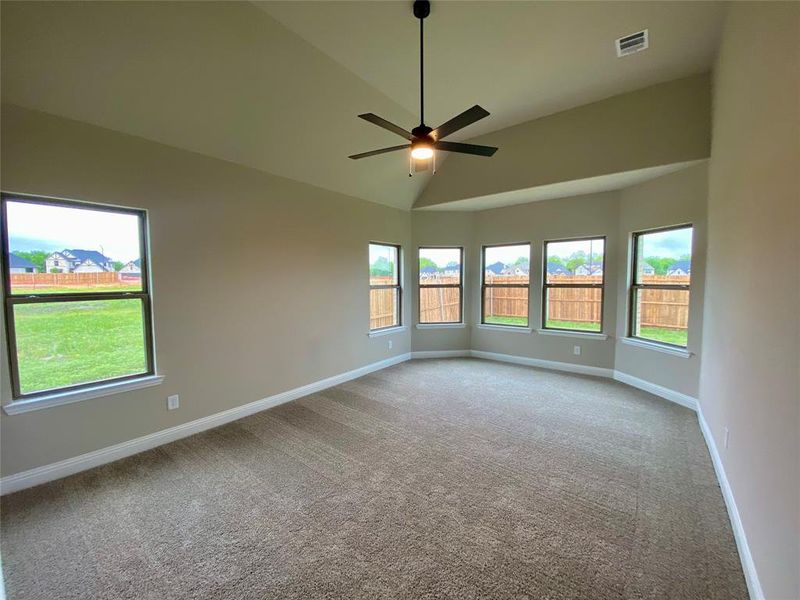 Master bedroom has bay window, vaulted ceilings, and a ceiling fan