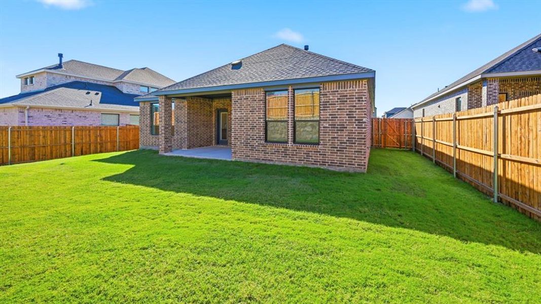 Back of property featuring a patio, brick siding, a shingled roof, and a fenced backyard