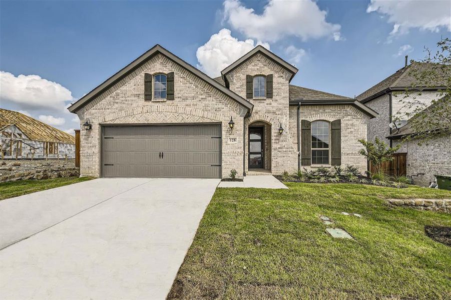 French country home with a garage and a front lawn