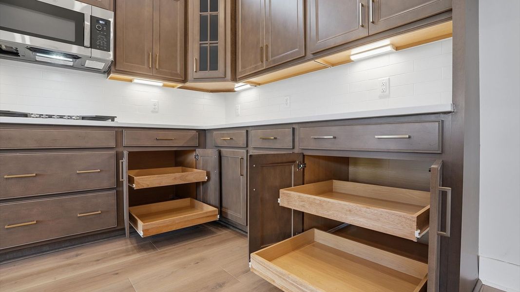Notable kitchen space with brown cabinetry and abundant storage space located at the Pelham Crossing community