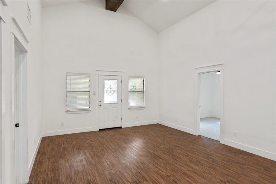 Entrance foyer featuring beamed ceiling, dark hardwood / wood-style floors, and high vaulted ceiling