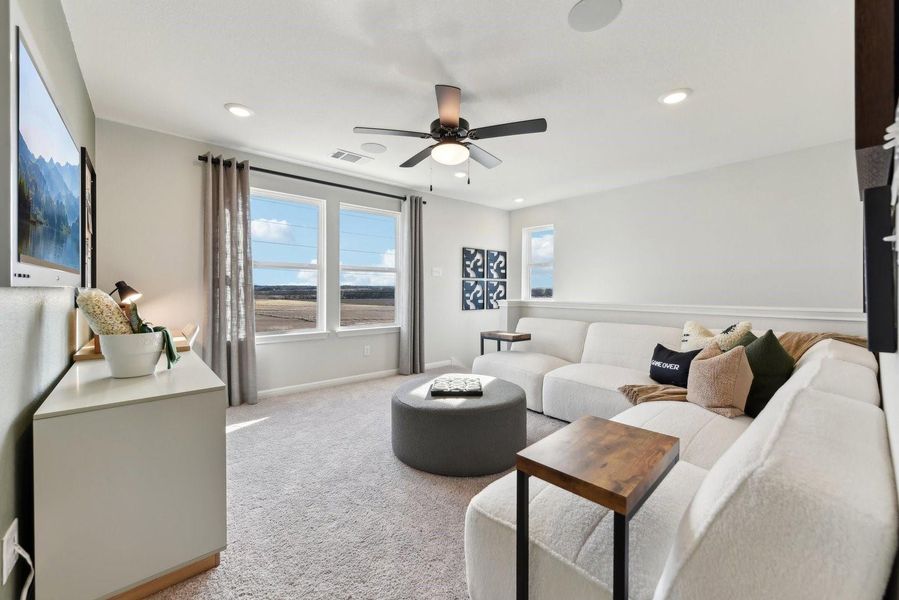 A spacious game room features soft wall-to-wall carpeting and multiple large windows.