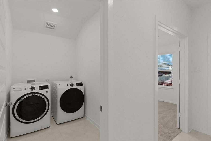 Laundry area featuring washer and clothes dryer, light tile patterned floors, and recessed lighting