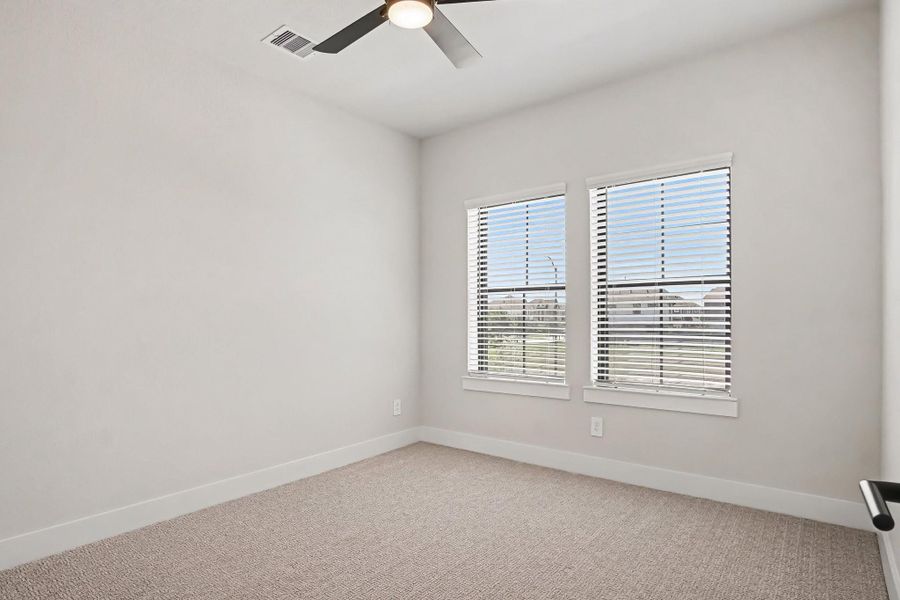 Upstairs bedroom with window blinds and ceiling fan. Upstairs bedroom with window blinds and ceiling fan.