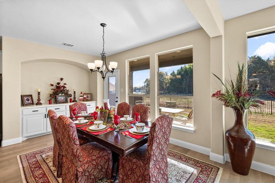 Dining space with plenty of natural light, light wood-style floors, and a chandelier Dining space with plenty of natural light, light wood-style floors, and a chandelier