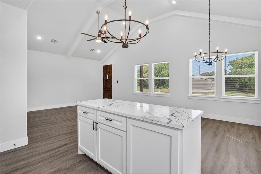 Central kitchen island with a patterned countertop and white cabinetry