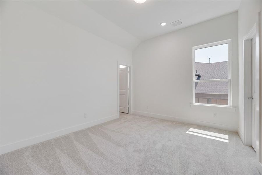 Unfurnished bedroom with carpet floors, vaulted ceiling, and recessed lighting