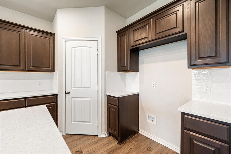 Kitchen with dark brown cabinets and light stone counters