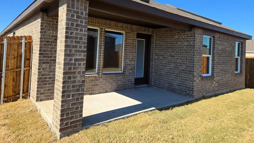 View of home's exterior featuring brick siding and a patio View of home's exterior featuring brick siding and a patio