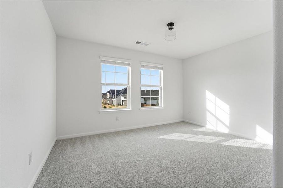 Room featuring two windows, light gray carpeting, white walls, and a contemporary flush-mount ceiling fixture