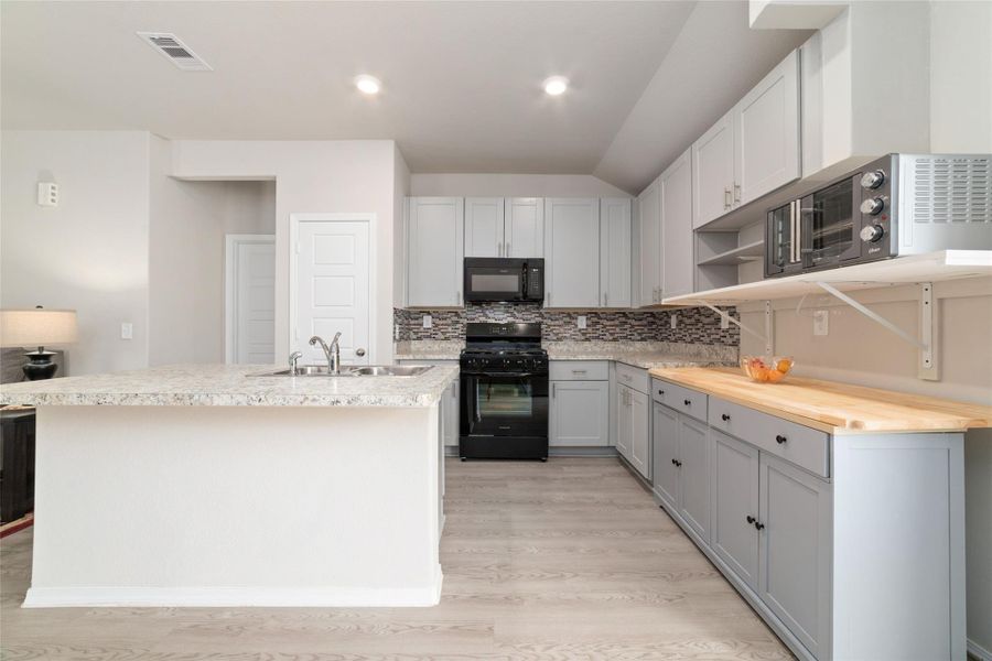 Open kitchen layout with abundant storage and natural light, designed to flow effortlessly into the dining and living areas.