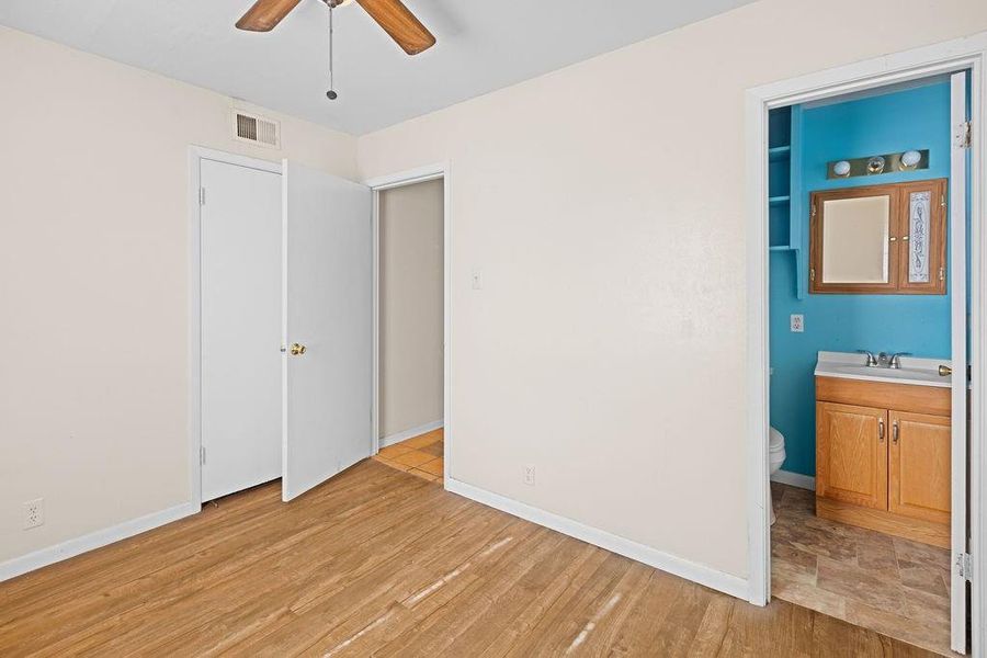 Primary bedroom 2 with connected bathroom, a ceiling fan, and light wood-type flooring