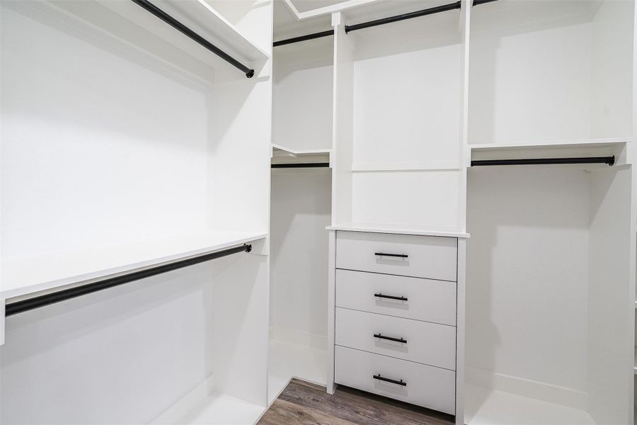 An organized closet system with built-in drawers and ample hanging space maximizes storage. An organized closet system with built-in drawers and ample hanging space maximizes storage.