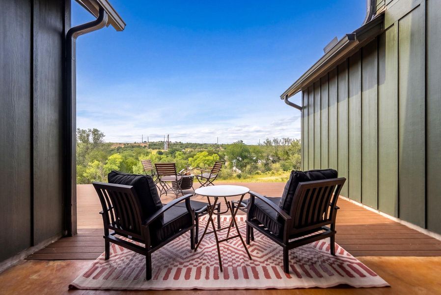 An open deck offers a serene vantage point looking out over rolling green hills.
