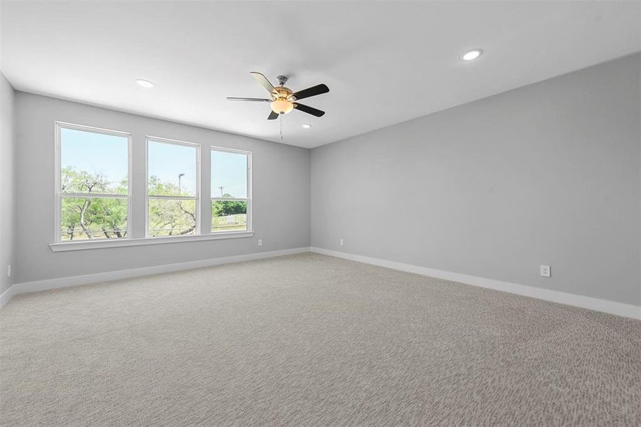 Carpeted spare room featuring ceiling fan