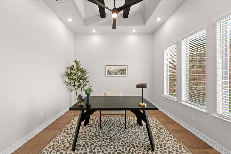 An inviting home office boasts a stylish ceiling fan and warm wood flooring. An inviting home office boasts a stylish ceiling fan and warm wood flooring.