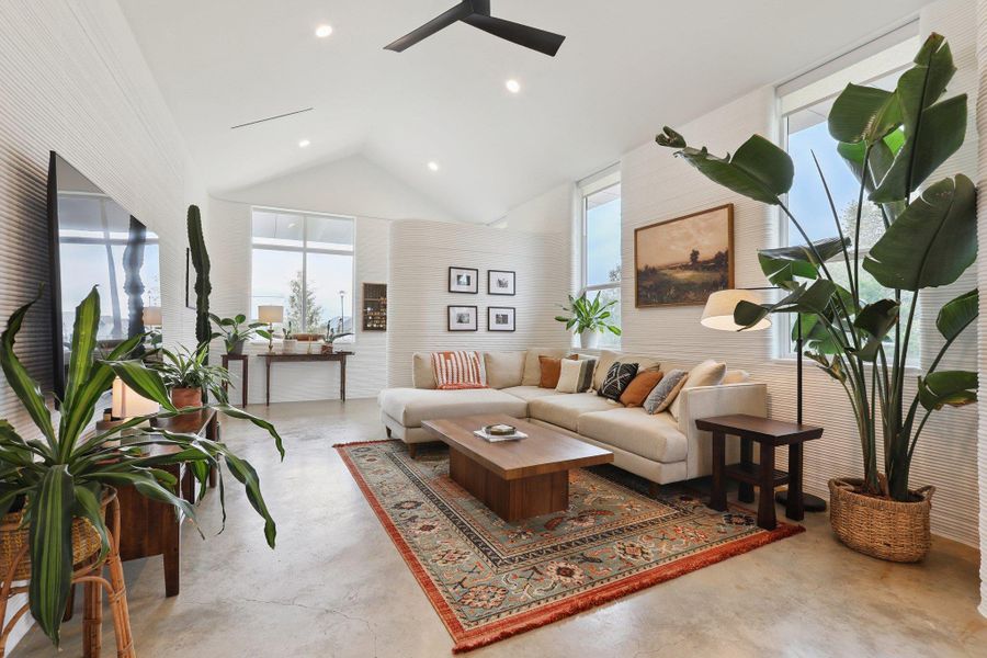 Living room with finished concrete flooring, ceiling fan, lofted ceiling, and recessed lighting
