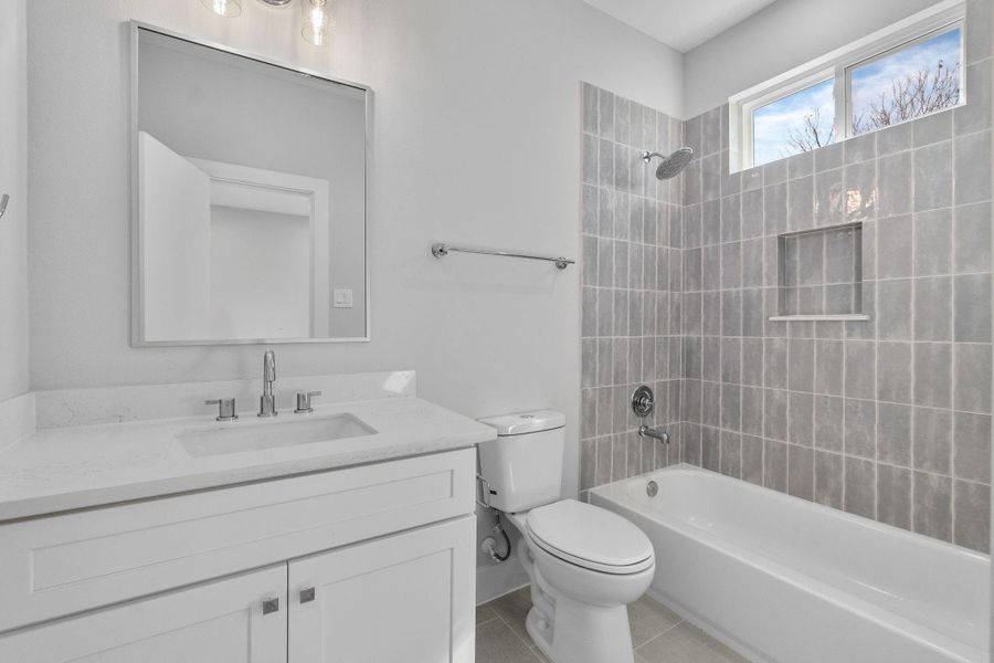 Well-appointed bathroom with contemporary finishes, neutral tile surround, and a window that brings in natural light.