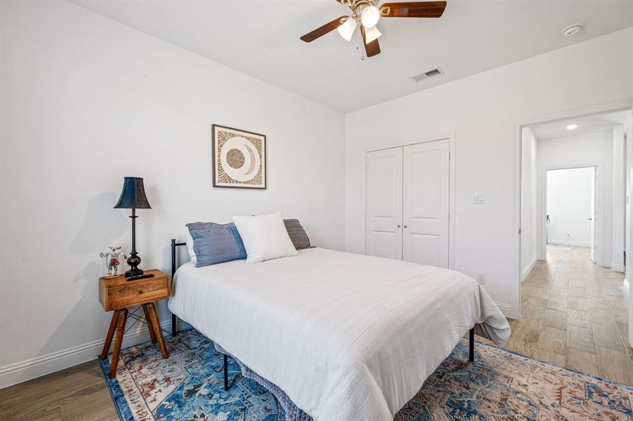 Bedroom featuring light wood finished floors, a ceiling fan, and a closet