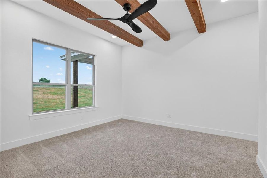 Carpeted room with exposed wood ceiling beams and a contemporary ceiling fan