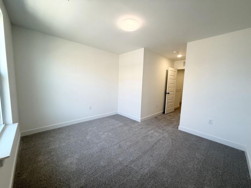 Spare room with dark carpet and baseboards