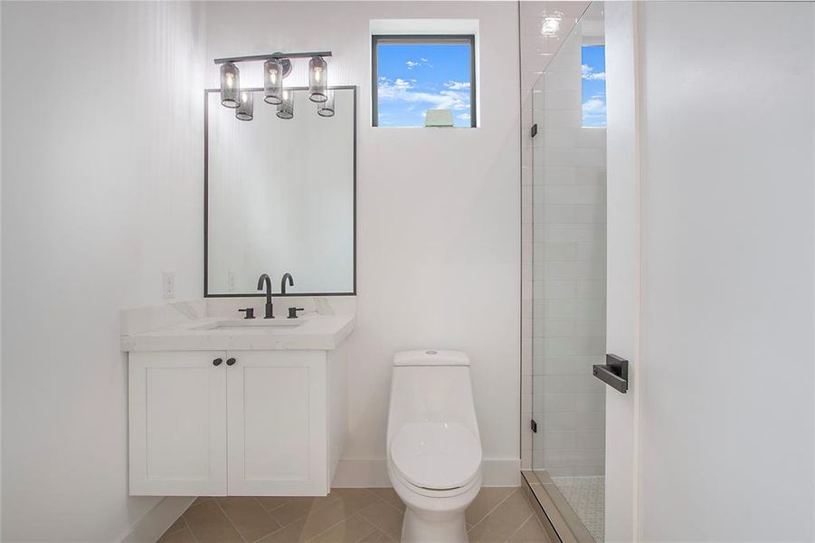 Bathroom with tile patterned flooring, vanity, an enclosed shower, and toilet