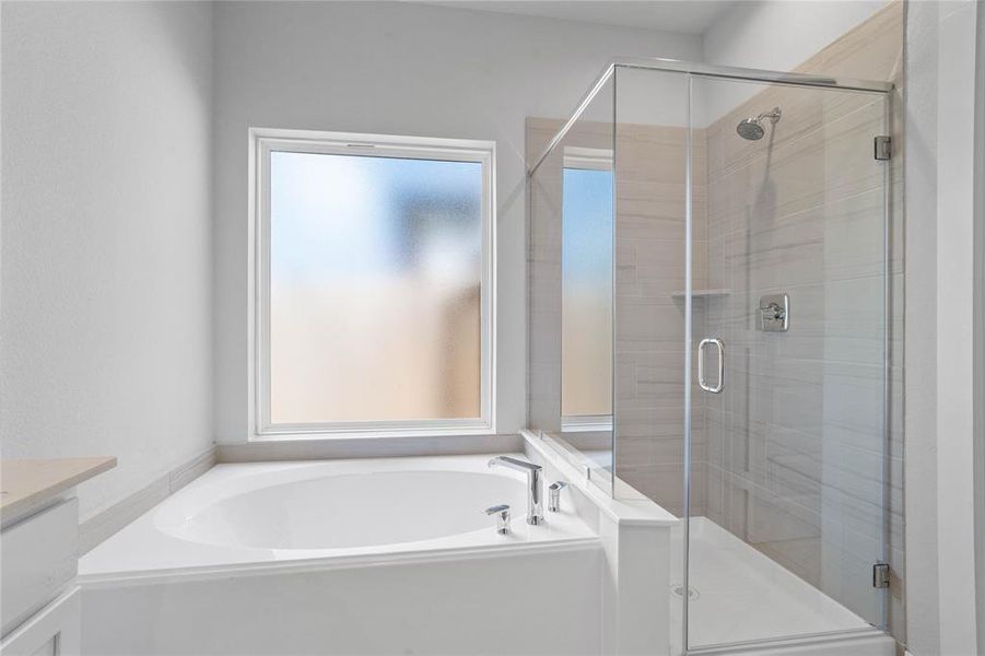 This primary bathroom is definitely move-in ready! Featuring dark framed walk-in shower with tile surround, separate garden tub for soaking after a long day with custom tile detailing, high ceilings, custom paint, sleek and dark modern finishes!