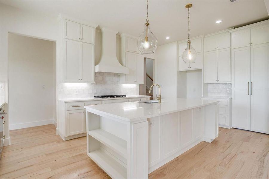 Kitchen featuring custom exhaust hood, gas stovetop, decorative backsplash, a sink, and recessed lighting