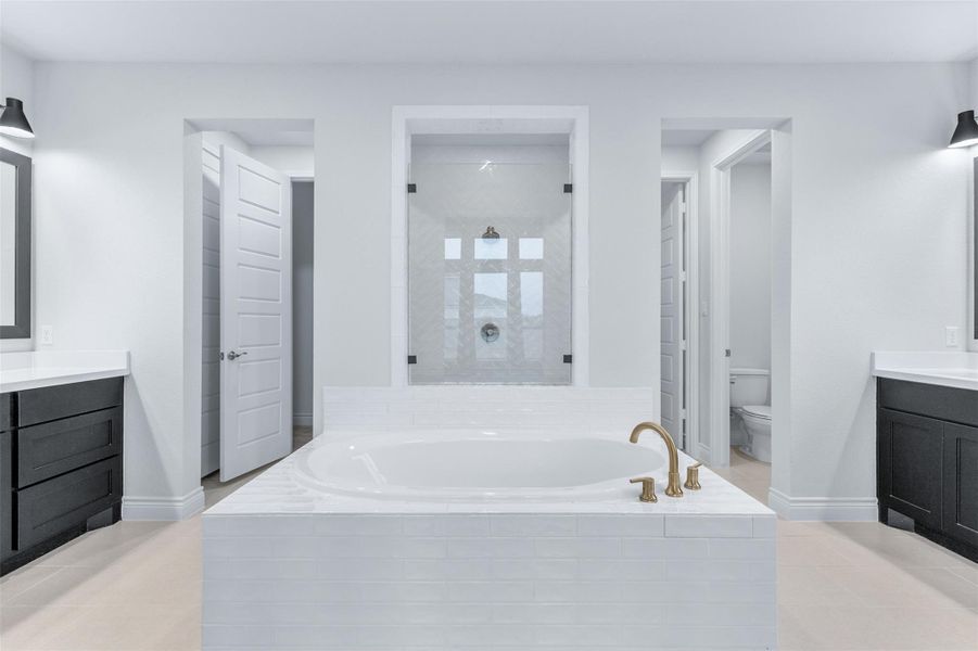 Full bath with vanity, a bath, a stall shower, and light tile patterned floors