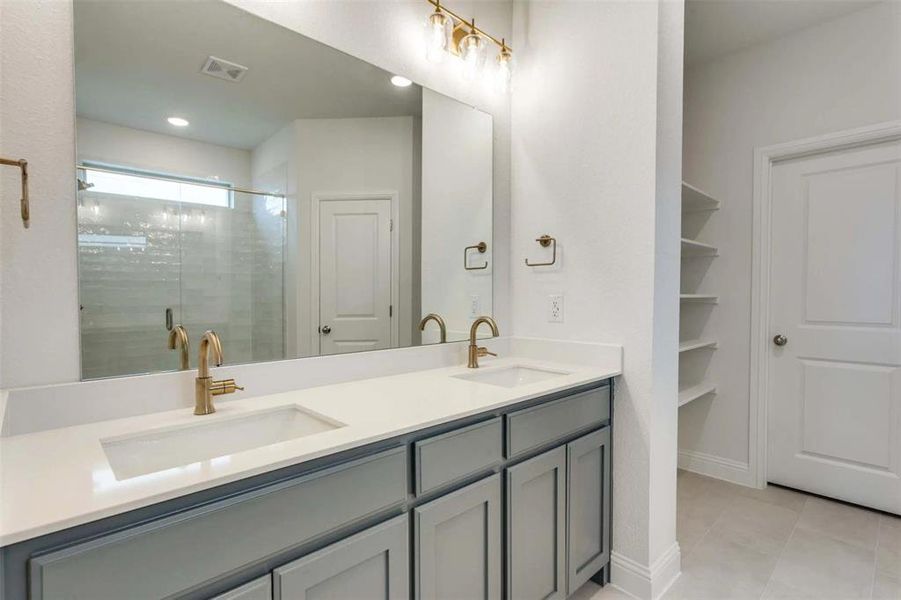 Full bathroom featuring double vanity, tile patterned flooring, a shower stall, and recessed lighting Full bathroom featuring double vanity, tile patterned flooring, a shower stall, and recessed lighting