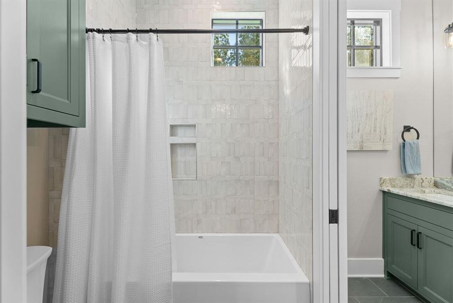 Full bath featuring vanity, shower / bath combo, and dark tile patterned flooring