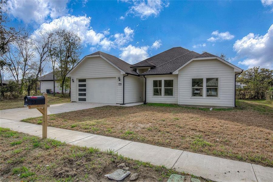 View of front of property featuring roof with shingles, concrete driveway, a front yard, and an attached garage View of front of property featuring roof with shingles, concrete driveway, a front yard, and an attached garage