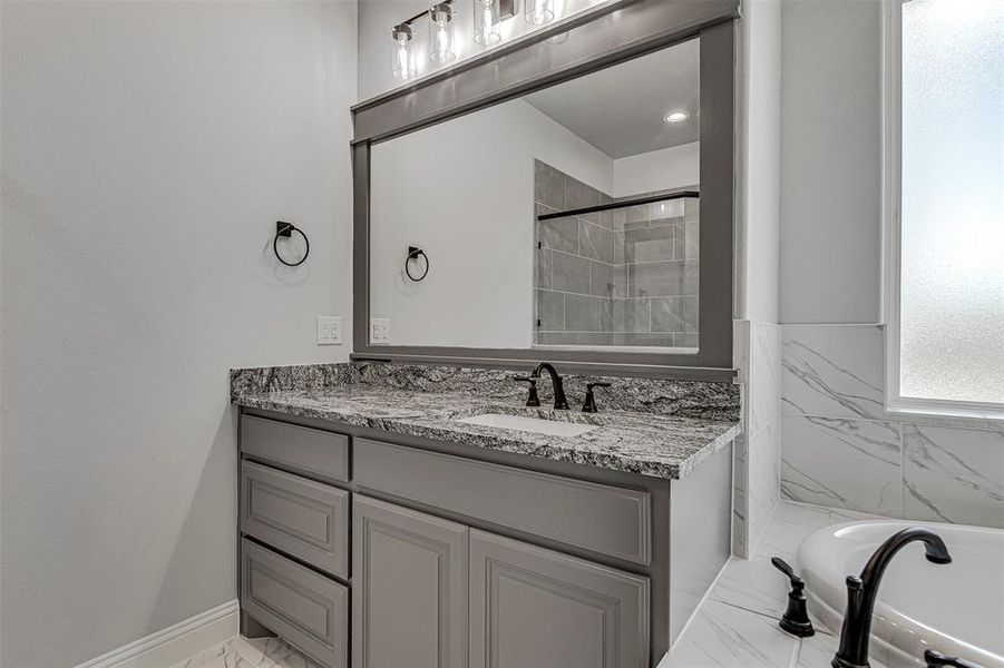 Bathroom featuring separate shower and tub and vanity