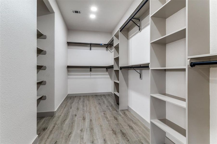 Walk in closet with light wood finished floors Walk in closet with light wood finished floors