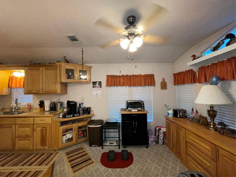 Kitchen with ceiling fan, lofted ceiling, and sink Kitchen with ceiling fan, lofted ceiling, and sink