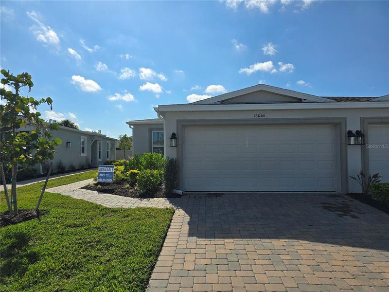 Front exterior of a new home in The Cove at West Port, Port Charlotte, FL, highlighting curb appeal (Image 1). Front exterior of a new home in The Cove at West Port, Port Charlotte, FL, highlighting curb appeal (Image 1).