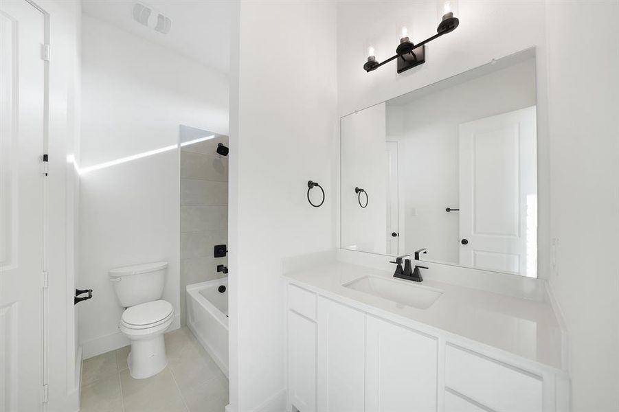 Full bathroom featuring  shower combination, vanity, and light tile patterned floors