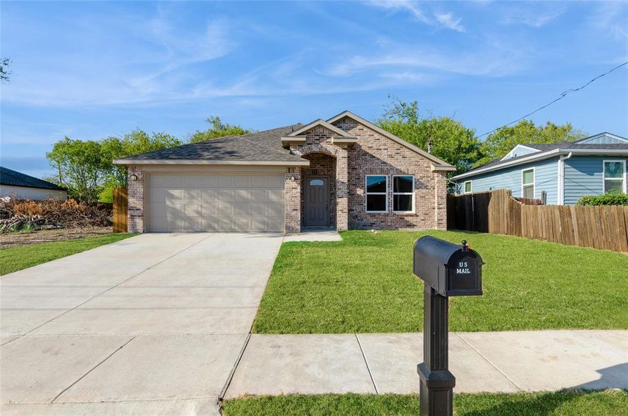 View of front of property featuring a front lawn and a garage