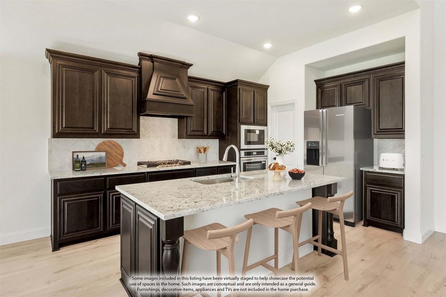 Kitchen with dark wood cabinets, granite island with seating, and stainless steel appliances on light hardwood floors