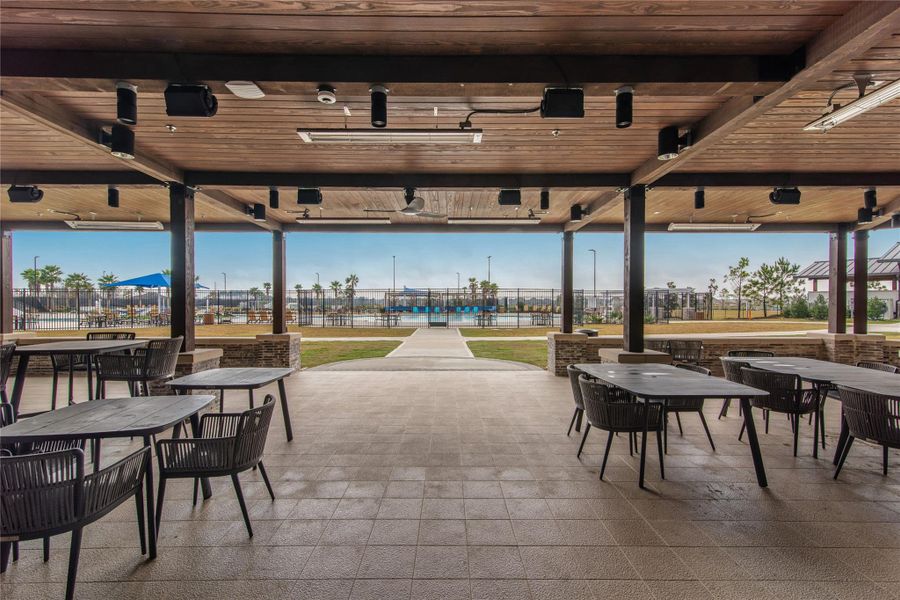 Experience a stunning view of the clubhouse from the covered seating area, perfect for relaxation and social gatherings.