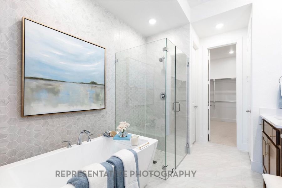Bathroom featuring a bath, a stall shower, vanity, a walk in closet, and recessed lighting