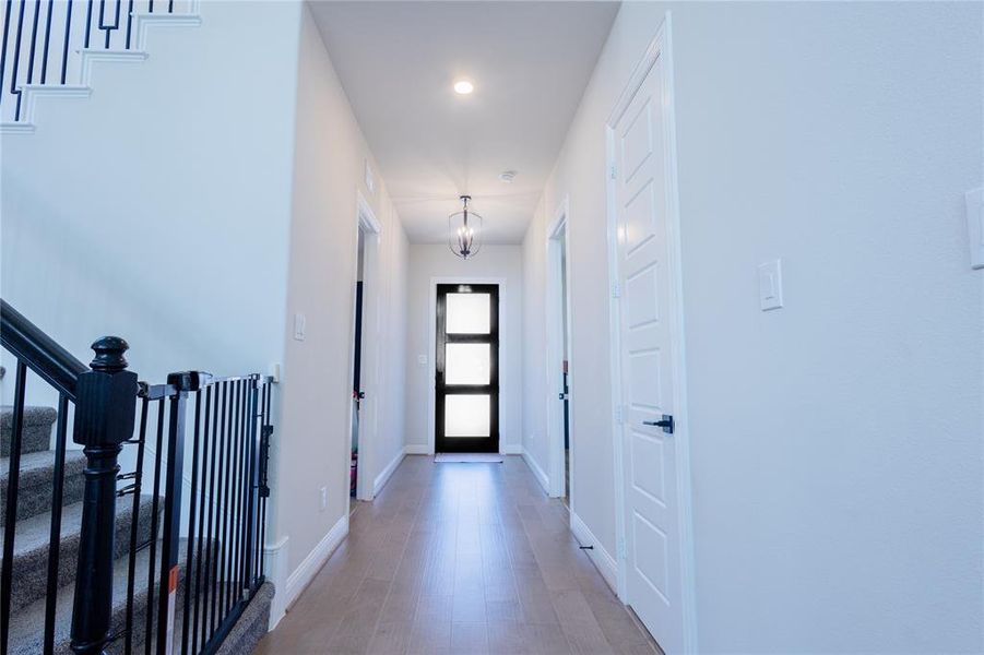 Hall with stairway, light wood-type flooring, a chandelier, and recessed lighting