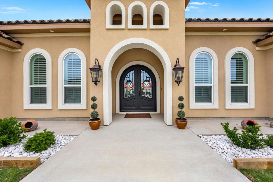 Grand arched entry with intricate ironwork doors welcomes you home. Grand arched entry with intricate ironwork doors welcomes you home.