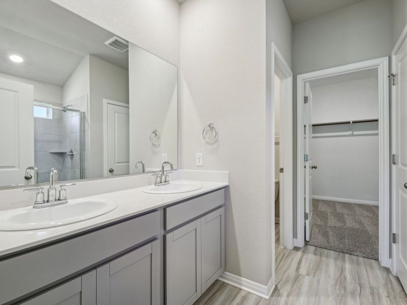 The primary bathroom includes dual-sinks and a walk-in shower.