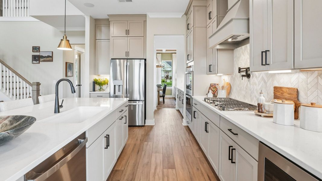View of kitchen with quartz countertops, tile backsplash, and pendant lighting View of kitchen with quartz countertops, tile backsplash, and pendant lighting