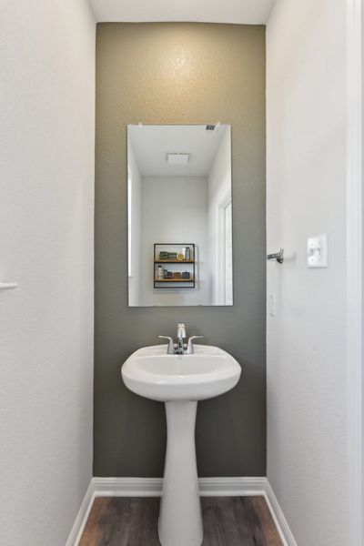 A bathroom with a mirror and sink. A bathroom with a mirror and sink.