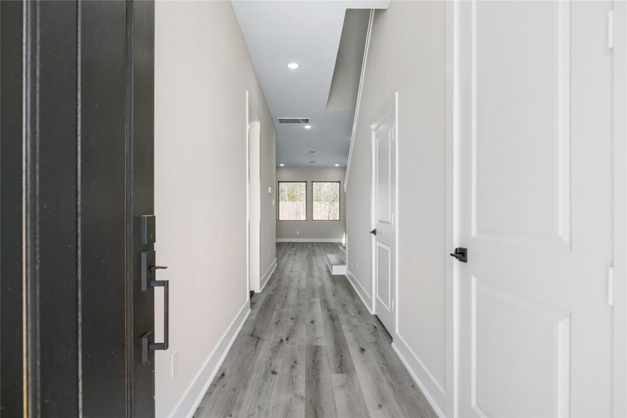 Welcome to your new home! Enter to a bright and welcoming entry leading directly to the well-lit living area adorned with large windows.